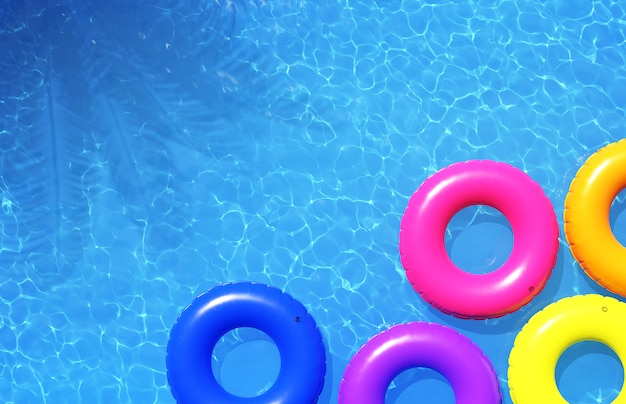 Colorful swimming rings in blue swimming pool, 3d illustration