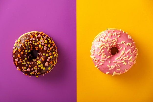 Colorful tasty glazed donuts on a colored.