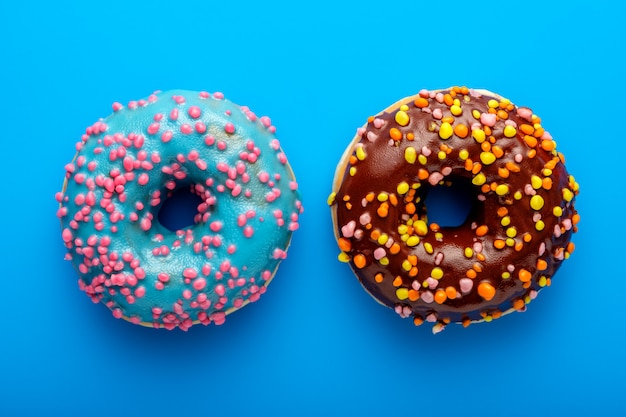 Colorful tasty glazed donuts on a colored.