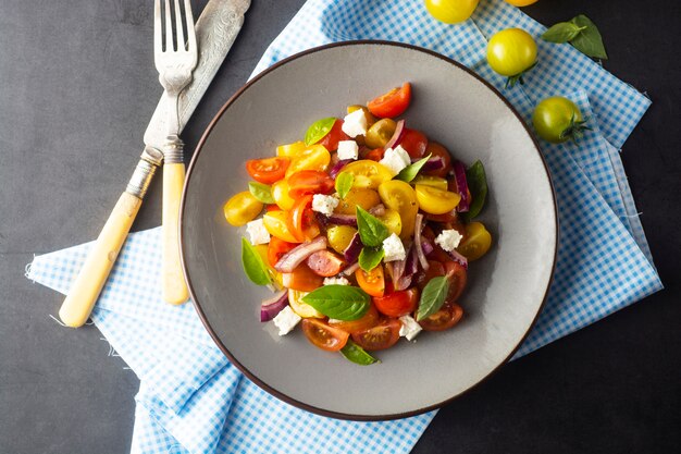 Colorful tomatoes and basil salad on a plate