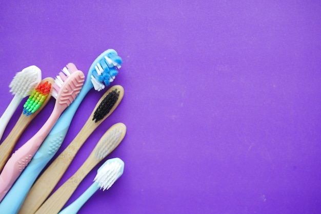 colorful toothbrushes on purple background