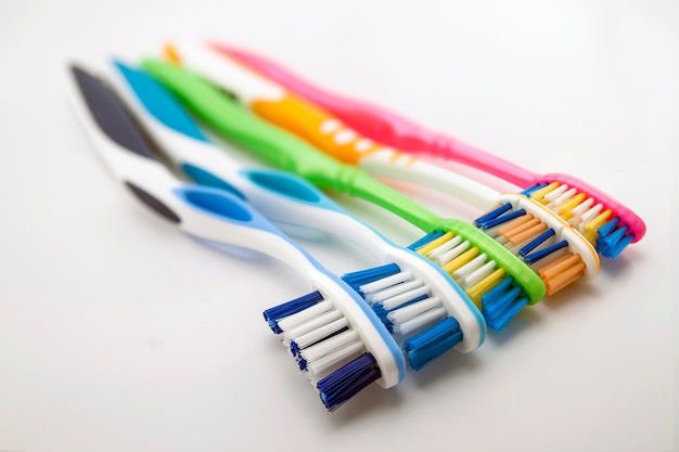 Colorful toothbrushes on white background with copy space. Macro with shallow dof.