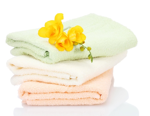 Colorful towels and flowers isolated on white