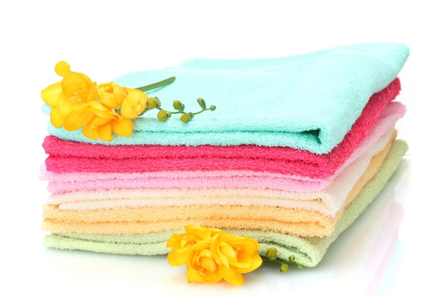 Colorful towels and flowers isolated on white