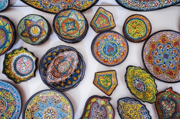 Photo colorful traditional asian uzbek ceramic plates handpainted at oriental souvenir tableware bazaar in uzbekistan