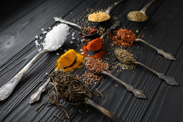 Colorful various herbs and spices for cooking on dark wooden rustic background