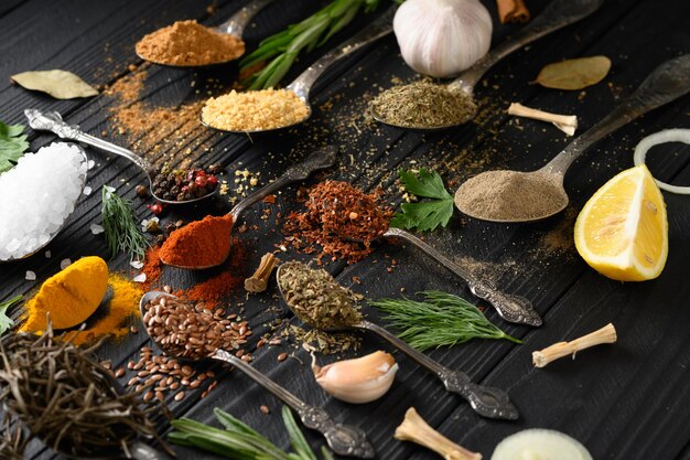 Colorful various herbs and spices for cooking on dark wooden rustic background