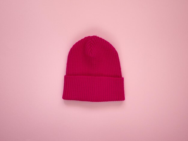 Colorful vivid knitted kids hat. Demi season autumn children's fashion wear. Top view on pink background