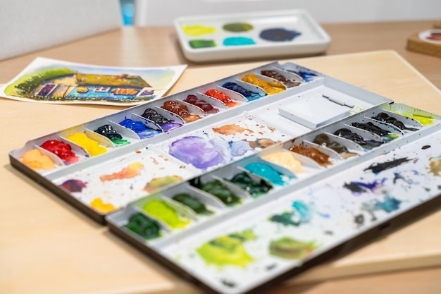 Colorful watercolor palette on table with watercolor set Selective focus