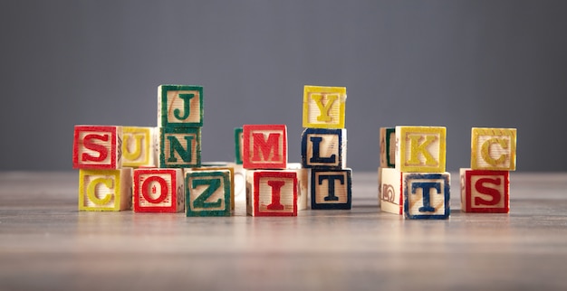 Colorful wooden cubes with letters on the wooden table.