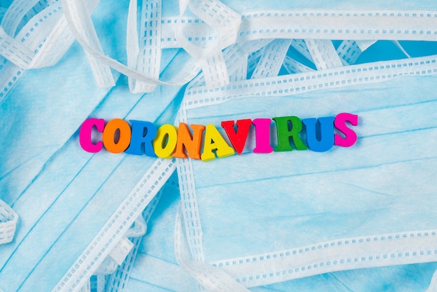 Colorful word coronavirus on protective masks. Top view.