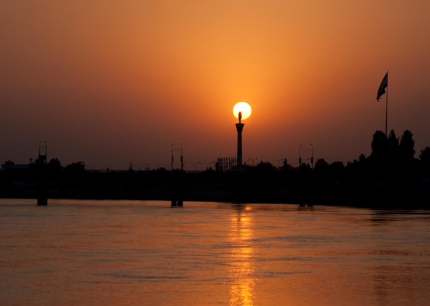 Colorfull sunset at the river bank against the background of the empty city