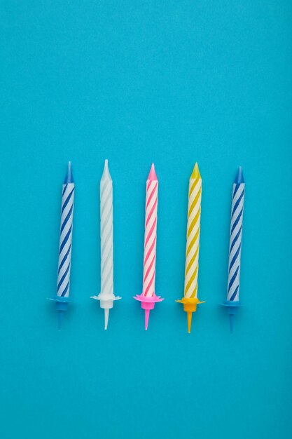 Coloruful birthday candles on blue background Birthday celebration Vertical photo