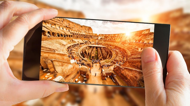 Colosseum or Coliseum in summer Rome Italy Tourist taking photo inside famous Colosseum by cell phone