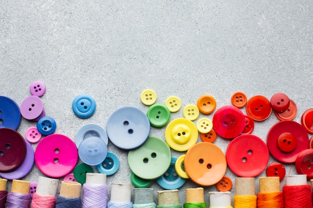 Coloured buttons and thread rolls with copy space background