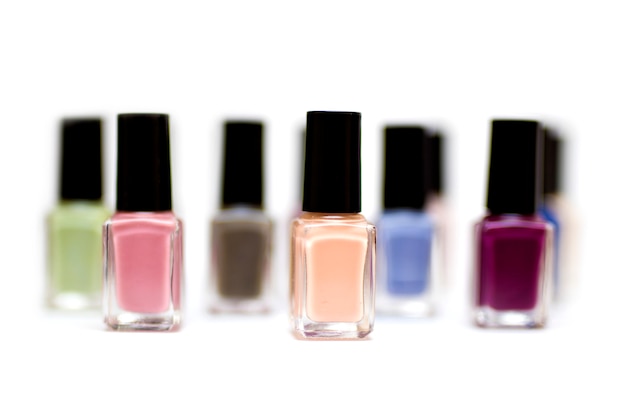 Coloured nail polish bottles on a white background