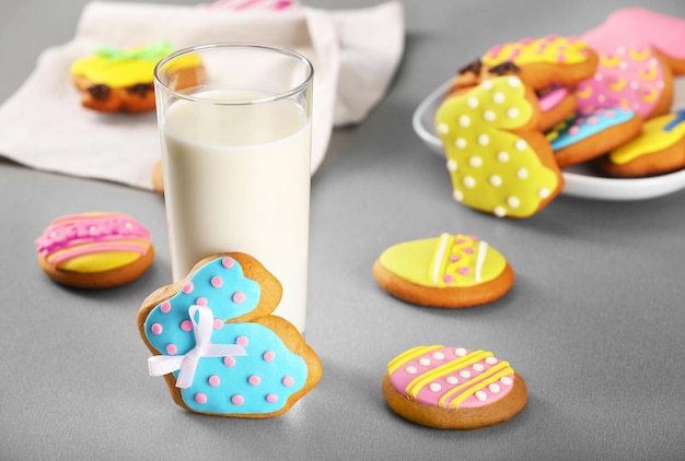 Colourful Easter cookies and glass of milk on kitchen table closeup