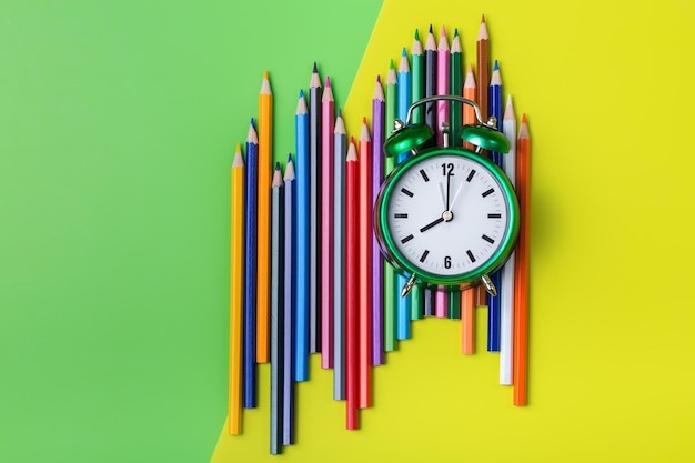 Colourful pencils and alarm clock Back to school concept