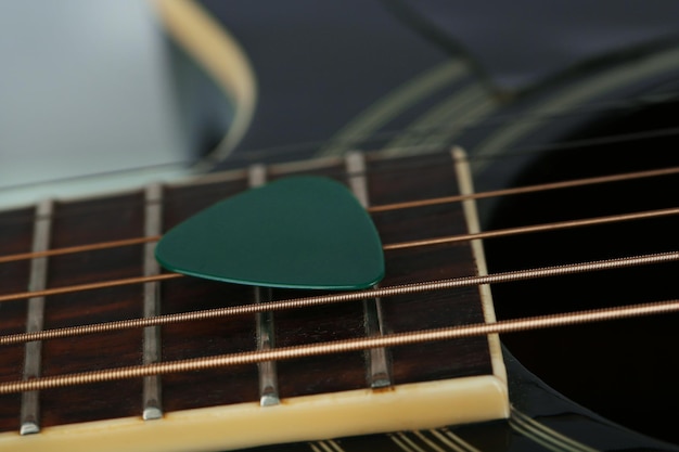 Colourful plectrum on guitar close up