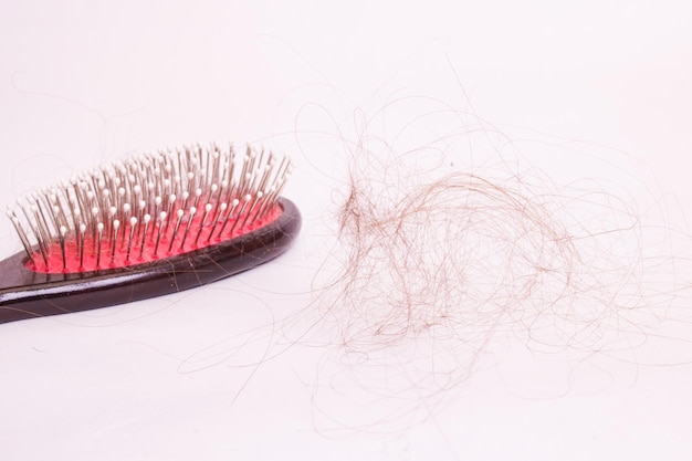 Comb and hair on white background alopecia