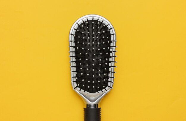 Comb on yellow background Beauty minimalistic concept