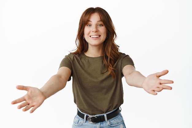 Come here Lovely smiling woman inviting and welcoming you spread hands sideways reaching for hug cuddle someone standing over white background