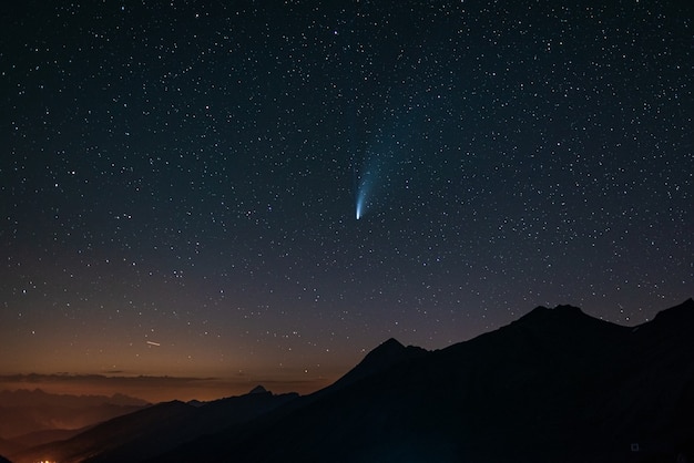 Comet Neowise twin tails glowing in the night sky. Telephoto view, details of the two star trails.