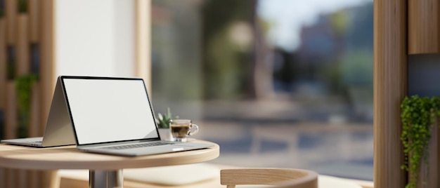 Comfortable coffee shop seating area near the window with a laptop on coffee table 3d rendering