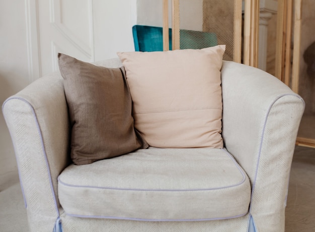 Photo comfortable upholstered chair with pillows in the interior of the apartment