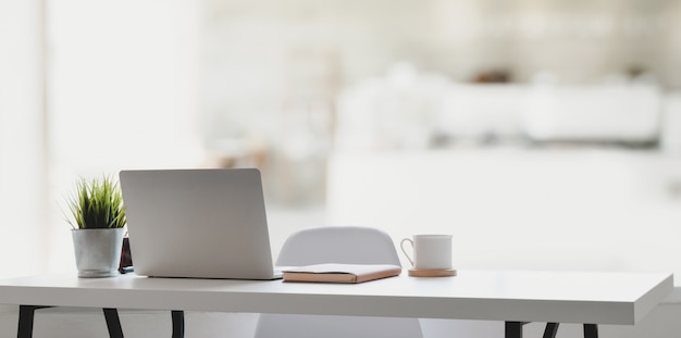 Comfortable workplace with laptop computer, coffee cup and office supplies 