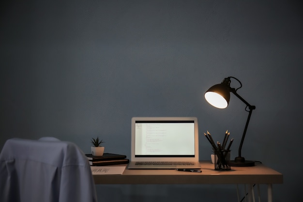 Comfortable workplace with laptop on desk at home