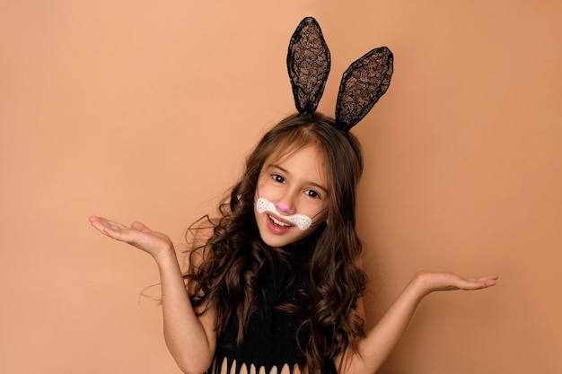 Comic girl dressed as a rabbit with a painted face spreads hands in surprise