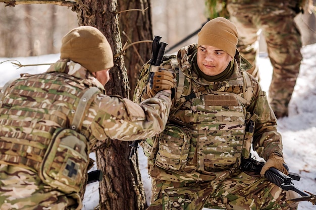 Command rangers during the military operation soldiers climbing on mountain one of them giving hand and helping to climb