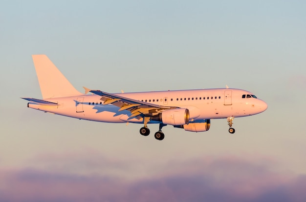 Commercial airplane landing at sunset