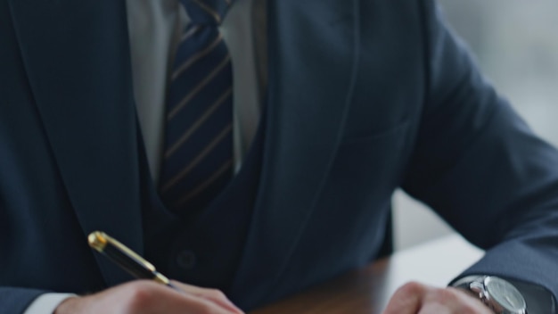 Commercial director signing papers with partnership agreement at office desk