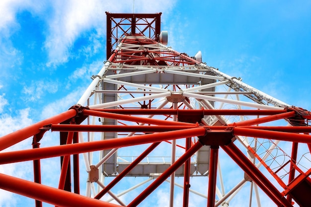 The communication tower stands against the sky with a bottomup view