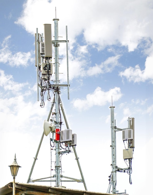 Communication tower with antennas on the top of building and bright blue sky background