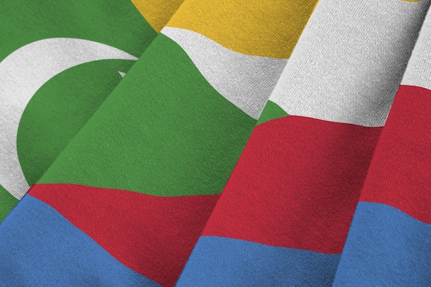 Comoros flag with big folds waving close up under the studio light indoors The official symbols and colors in banner