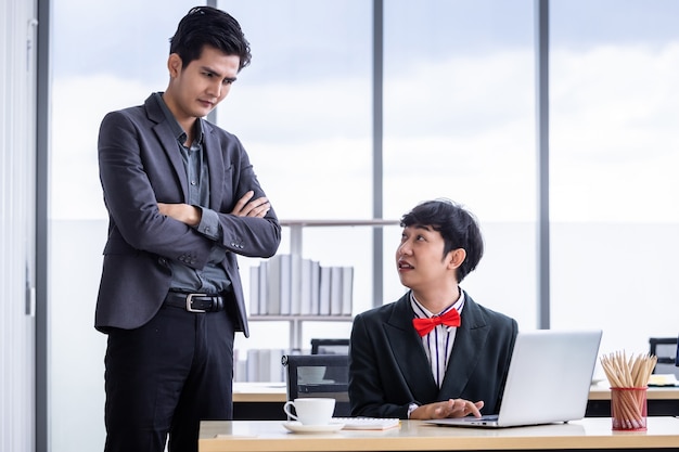 Company executive Young Asian businessman with arms folded and coaching personal Employees Homosexual businessman LGBT partners while working together with laptop computer in office.