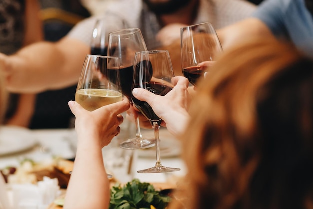 Company of friends having fun at dinner in a restaurant On the table a variety of dishes from the chef They clicked their glasses of wine Conceptual photography View from above