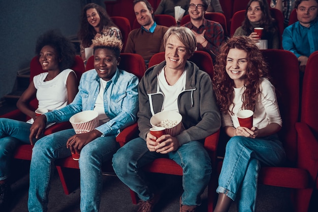 Company of friends is watching comedy in cinema