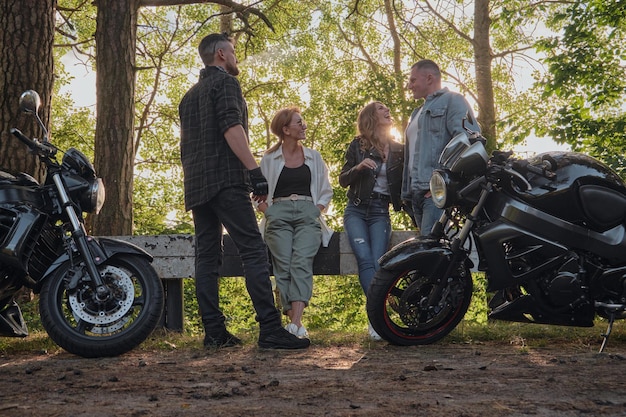 A company of friends travel together on motorcycles stopped at the roadside have fun and drink tea