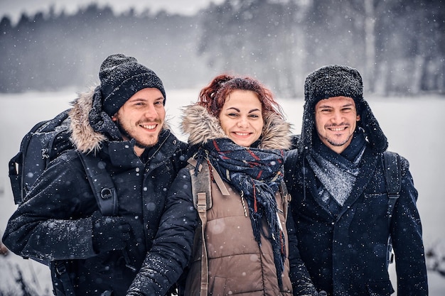 A company of three friends travels through the winter forest