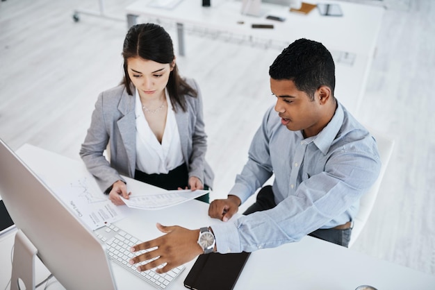 The companys top performance boosters Shot of a young businessman and businesswoman using a computer in a modern office