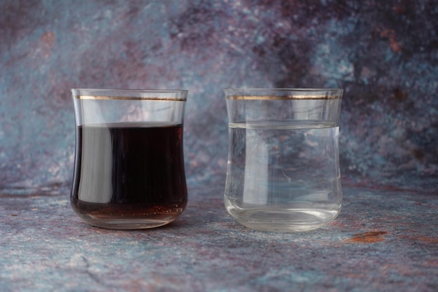 Comparing soft drinks and glass of water on table