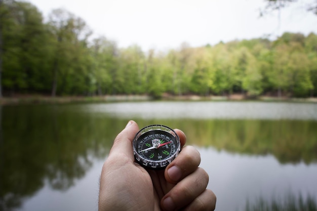 Compass on the background of a forest lake