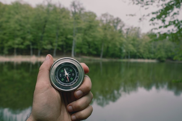 Compass on the background of a forest lake