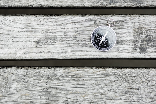 Compass on a beautiful wooden surface. Top view