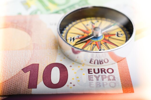 Compass and Euro banknotes as business currency finance concept