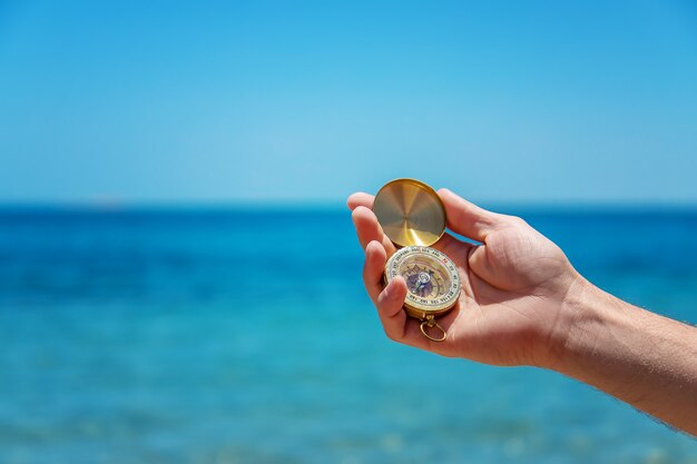 Compass in hand against the sea